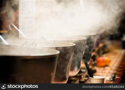 Boiling cauldrons or big pots on street food festival. Boiling cauldrons or big pots