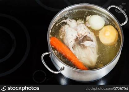 boiling of chicken broth in steel pan on glass ceramic cooker
