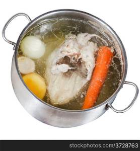 boiling of chicken soup with seasoning vegetables in steel pan isolated on white background
