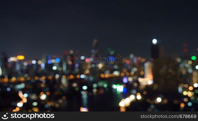 Bokeh background of skyscraper buildings in city with lights, Blurry photo at night time. Cityscape