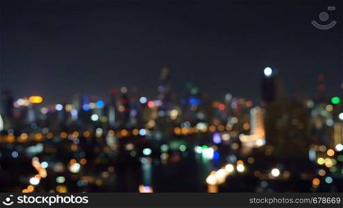 Bokeh background of skyscraper buildings in city with lights, Blurry photo at night time. Cityscape