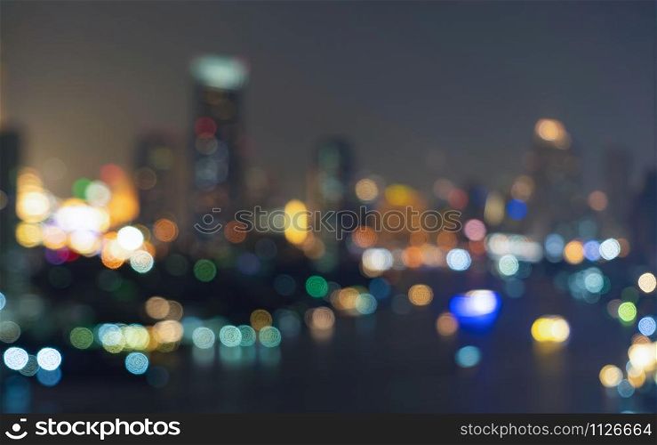 Bokeh background of skyscraper buildings in downtown. Urban city with lights, Blurry photo at night time. illuminated Cityscape