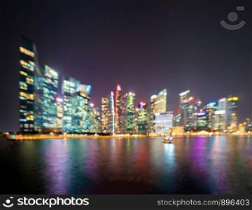 Bokeh background of skyscraper buildings in Singapore City Downtown with lights, Blurry photo at night time. Cityscape