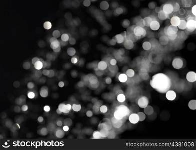 bokeh lights on black background, shot of flying drops of water in the air
