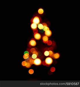 Bokeh silhouette of Christmas tree on black background