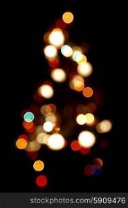 Bokeh silhouette of Christmas tree on black background. Bokeh silhouette of Christmas tree