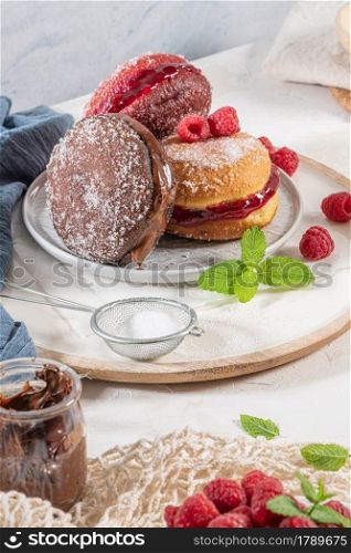 "Bolas de Berlim, or "Berlin Balls". Portuguese fried dough with sugar, Filled with chocolate or raspberry jam. Portuguese fried dough with sugar. Chocolate and beetroot berliner Pancakes Doughnuts Donuts stuffed with various creams"
