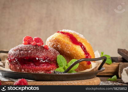 "Bolas de Berlim, or "Berlin Balls". Portuguese fried dough with sugar, Filled with chocolate or raspberry jam. Portuguese fried dough with sugar. Chocolate and beetroot berliner Pancakes Doughnuts Donuts stuffed with various creams"