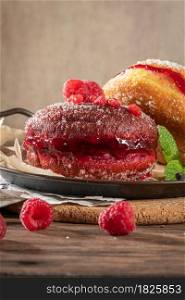 "Bolas de Berlim, or "Berlin Balls". Portuguese fried dough with sugar, Filled with chocolate or raspberry jam. Portuguese fried dough with sugar. Chocolate and beetroot berliner Pancakes Doughnuts Donuts stuffed with various creams"