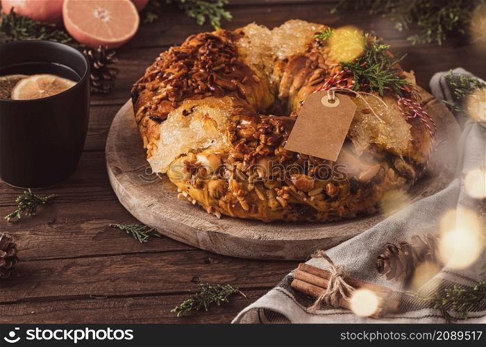 Bolo rainha or queen&rsquo;s cake is a traditional portuguese Xmas cake with fruits raisins nut and icing on kitcthen countertop. Served with orange tea. Wooden backgroun. Is made for Christmas, Carnavale or Mardi Gras