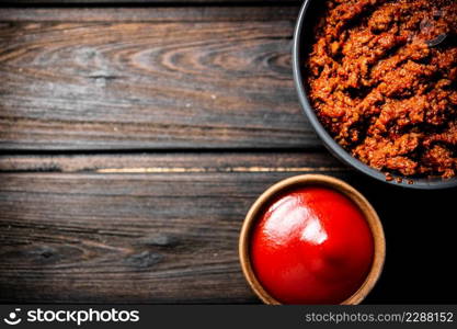 Bolognese sauce with tomato sauce in bowls. On a wooden background. High quality photo. Bolognese sauce with tomato sauce in bowls.