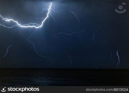 Bolt of lightening in a night sky. Bolt of lightening in a night sky during a thunderstorm with copy space in a weather or meteorology concept