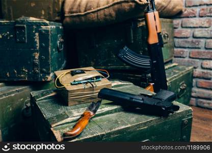 Bomb, knife, gun and kalashnikov rifle on box of ammunition, nobody. Terrorism and terror horror concept. Mojahed kit. Bomb, knife, gun and rifle on box of ammunition