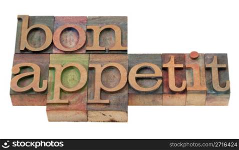 bon appetit - phrase in vintage wooden letterpress printing blocks, stained by color inks, isolated on white