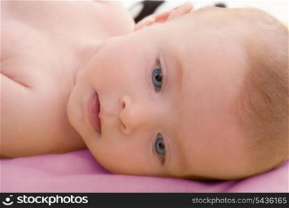 Bond little baby blue eyes lying relaxed in pink bed