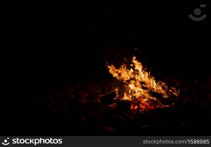Bonfire made inside a circle of stones at night.