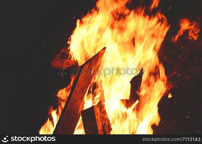 bonfire night campfire wood burning flame on dark black , selective focus