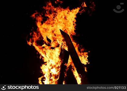 bonfire night campfire wood burning flame on dark black , selective focus