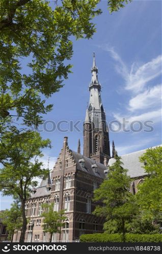 boniface church and blue sky in leeuwarden capital of friesland on sunny summer day seen through trees