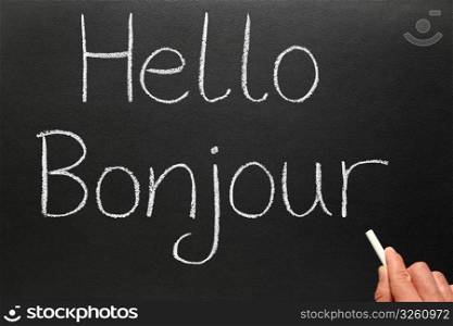 Bonjour, hello in French written on a blackboard.