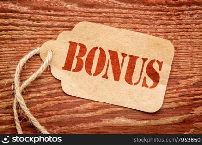 bonus sign a paper price tag against rustic red painted barn wood - shopping concept