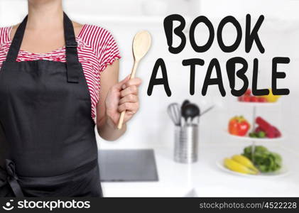 book a table cook holding wooden spoon concept. book a table cook holding wooden spoon concept.