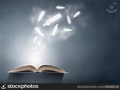 Book and light bulb. Opened book and glowing light bulbs flying from pages