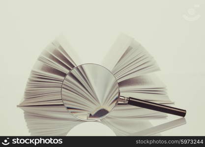 Book and magnifying glass isolated on white. Search concept. Search concept vintage