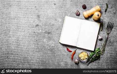 book of recipes. Fresh spices and herbs. On a stone background.. Fresh spices and herbs
