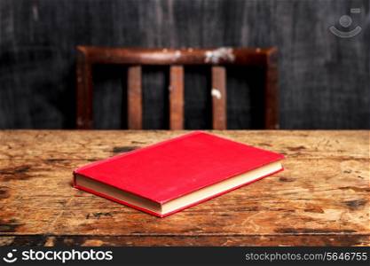 Book on desk with blackboard in background