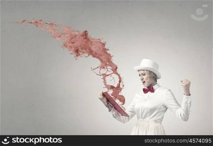 Book that blow up your imagination. Young woman in white hat with opened book in hands and splashes flying out