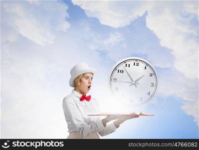 Book that blow up your imagination. Young woman in white hat with opened book in hands and clock on pages