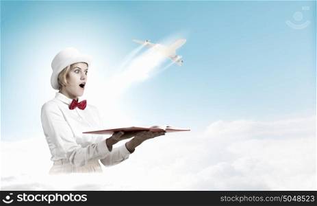 Book that blow up your imagination. Young woman in white hat with opened book in hands and airplane flying out