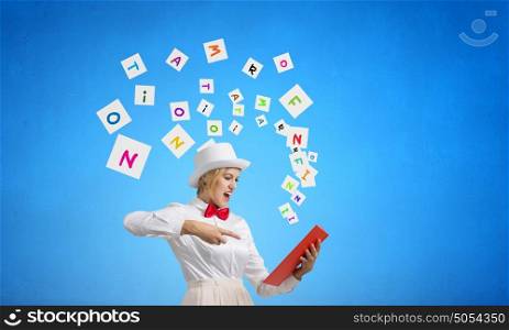 Book that blow up your imagination. Young woman in white hat with opened book in hands and characters flying out