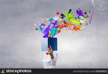 Book that blows up your mind. Woman with opened book against her face and colorful splashes coming from pages