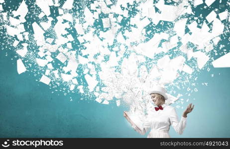 Book that blows up your mind. Young woman in white hat with opened red book in hands