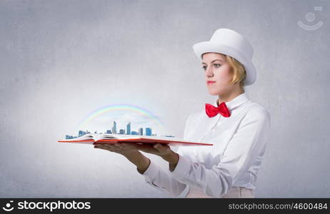 Book that develope your imagination. Young woman in white cylinder and red bowtie with book in hands