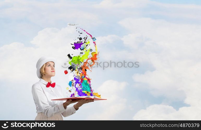 Book that develope your imagination. Young woman in white cylinder and red bowtie with book in hands