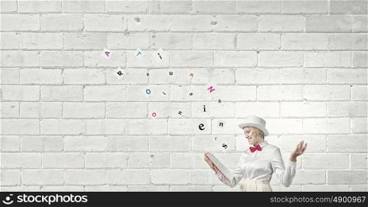 Book that develope your imagination. Young woman in white cylinder and red bowtie with book in hands
