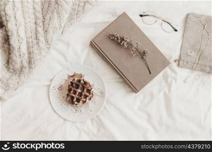 book with herb near bun plate other things bedsheet