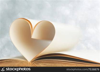 Book with opened pages and shape of heart love reading concept. Book with pages shape of heart