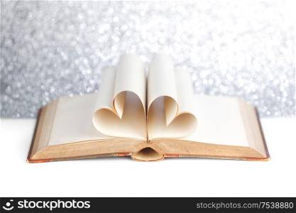 Book with opened pages and shape of heart love reading concept. Book with pages shape of heart