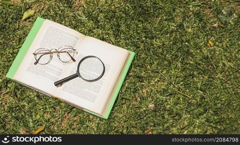 book with optical implements green grass