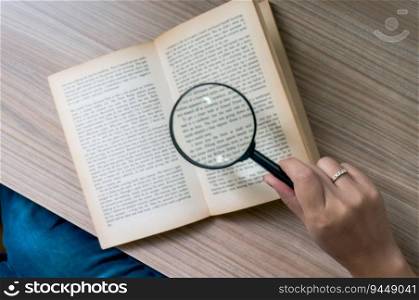 Books and a magnifier Research concept. Magnification glass over opened book