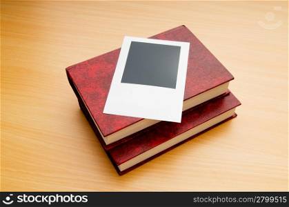 Books and blank photos on wooden table