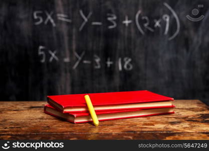 Books and chalk with math problem in background