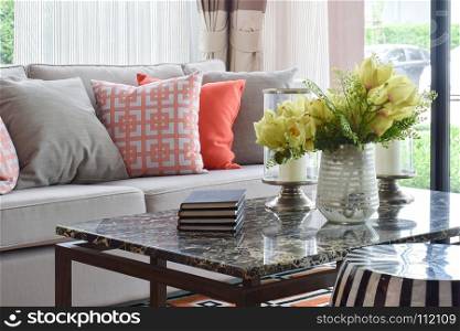 Books and decorative items on marble top table and lively sofa set