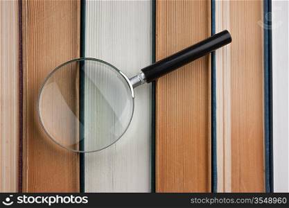 books and magnifying glass isolated on white background