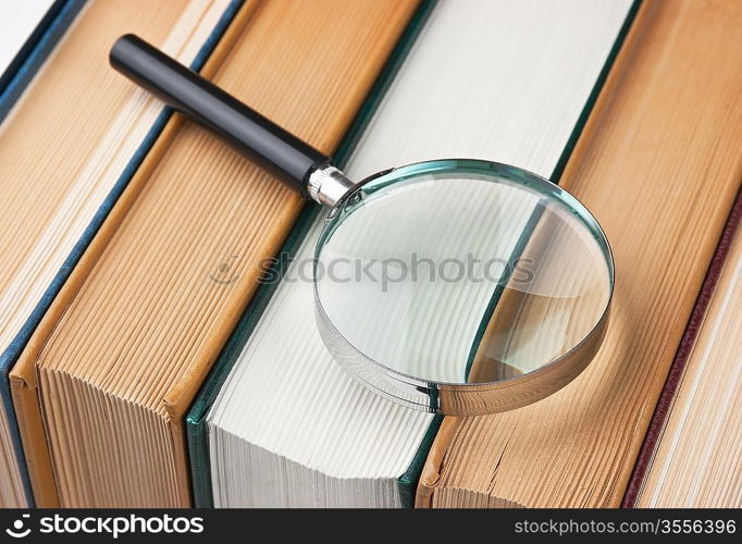 books and magnifying glass isolated on white background