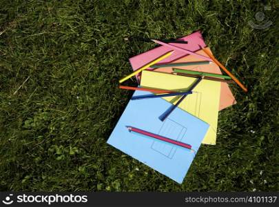 Books and pencils on the grass